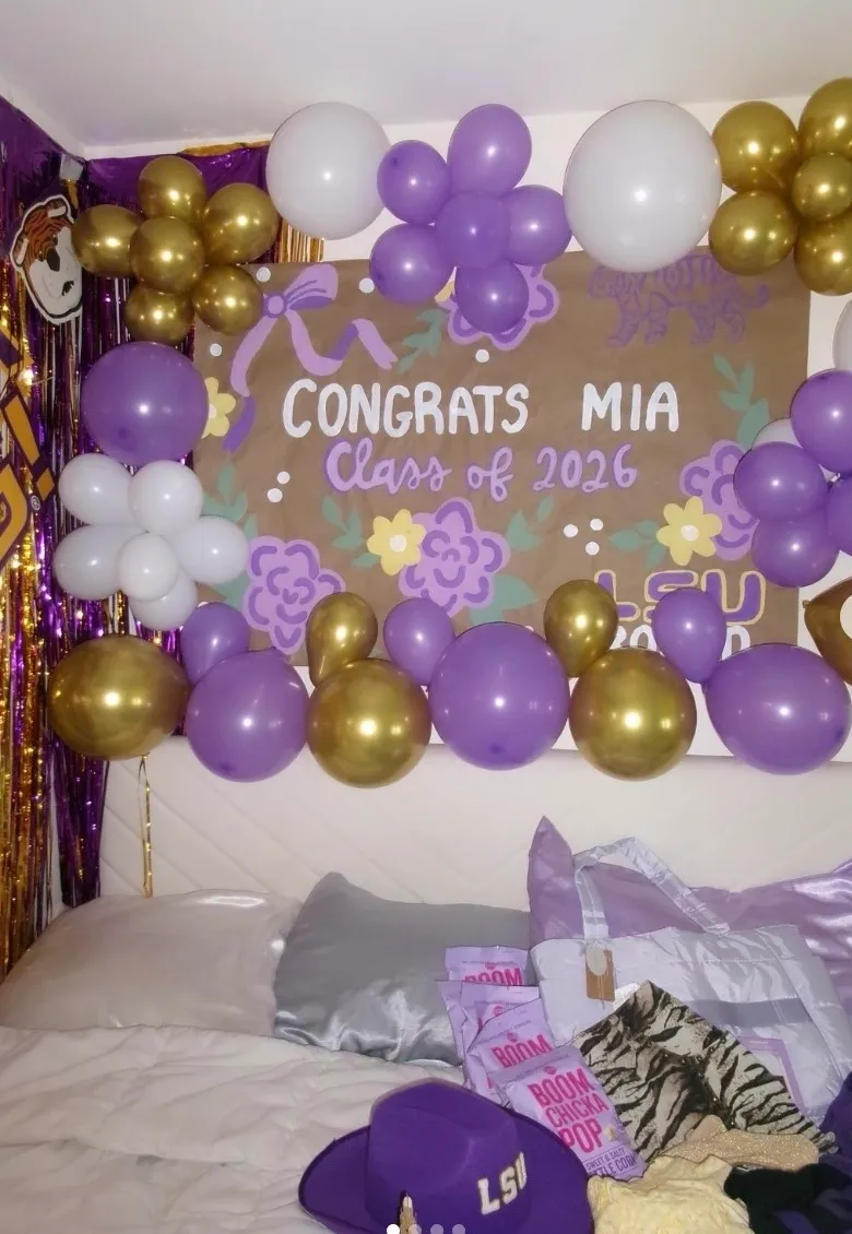 Purple and gold LSU commitment banner surrounded by balloon garland